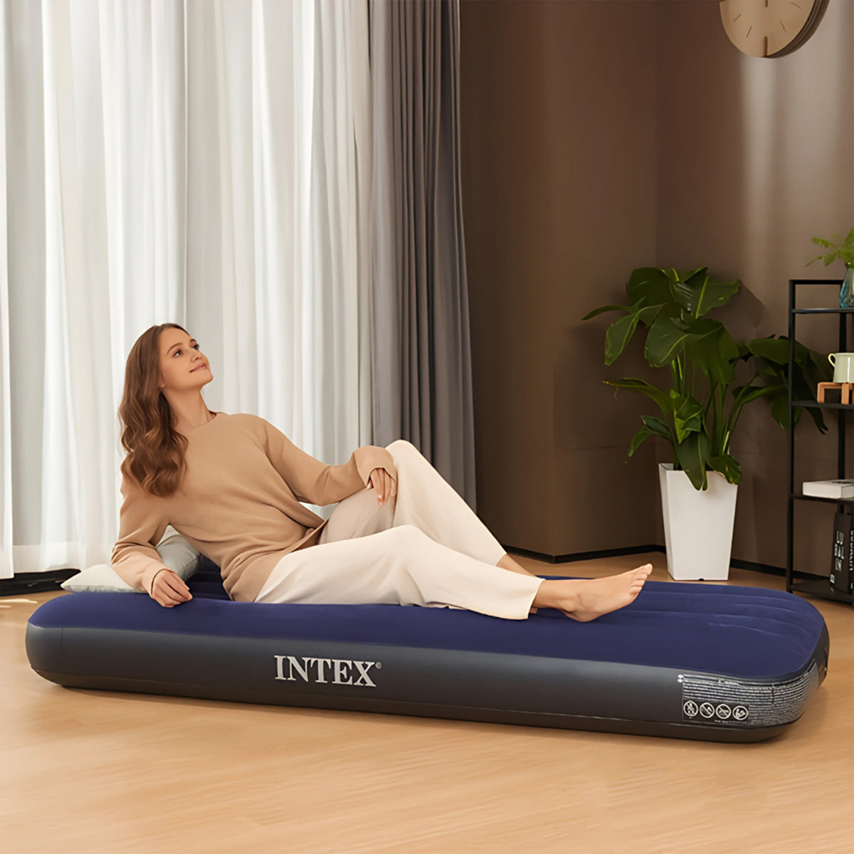 Cama portatil inflable preparada en una recamara de visitas con sabanas y almohadas
